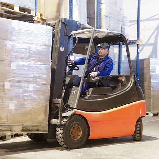 Forklift handling wrapped cargo in a warehouse
